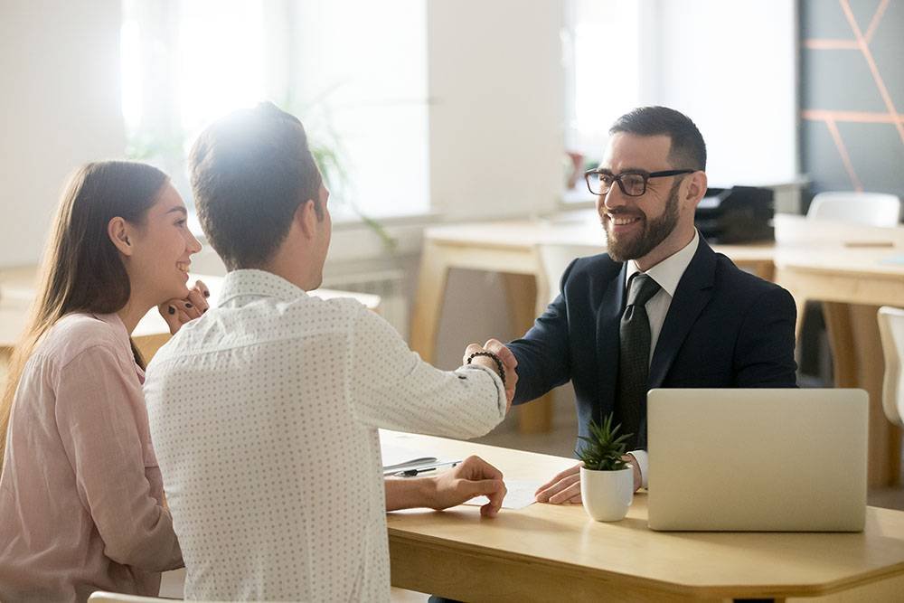 Financial Advisor Handshaking Young Couple