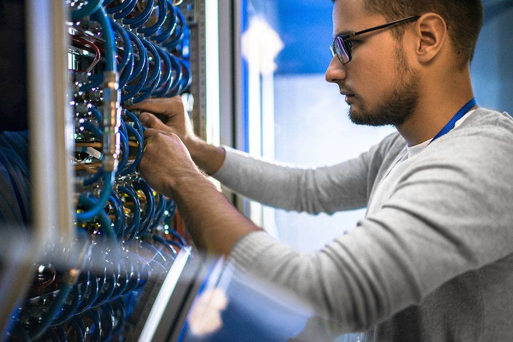 Man Connecting Cables in Server Cabinet