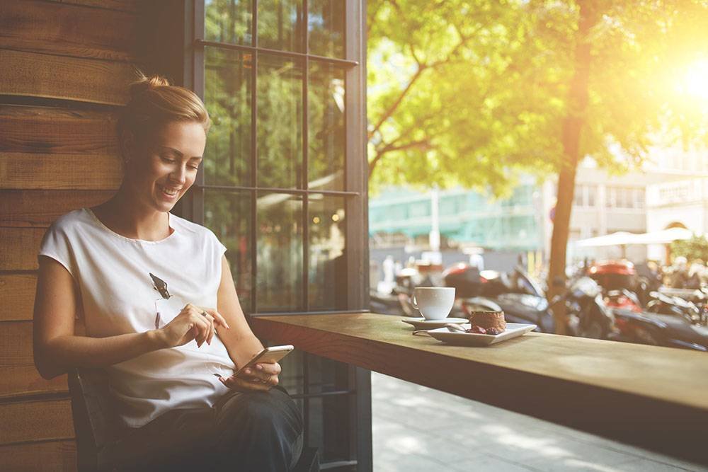 Woman Using Mobile Phone at Cafe