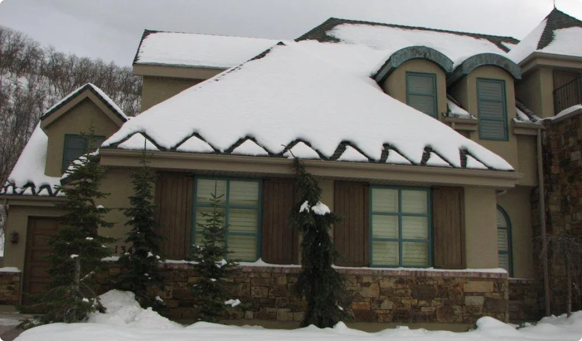 Ice and Snow Can Damage Your Roof and Home, part of a home with an ice-melting system on it