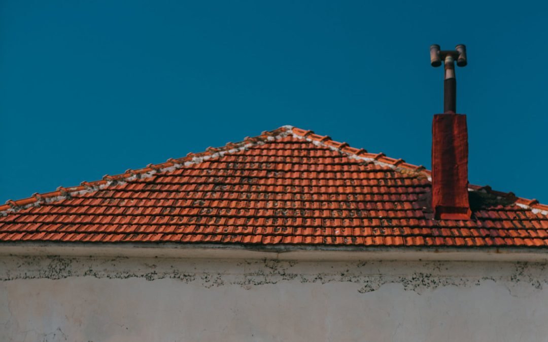 view of a roof with orange roof tiles that are dirty and worn